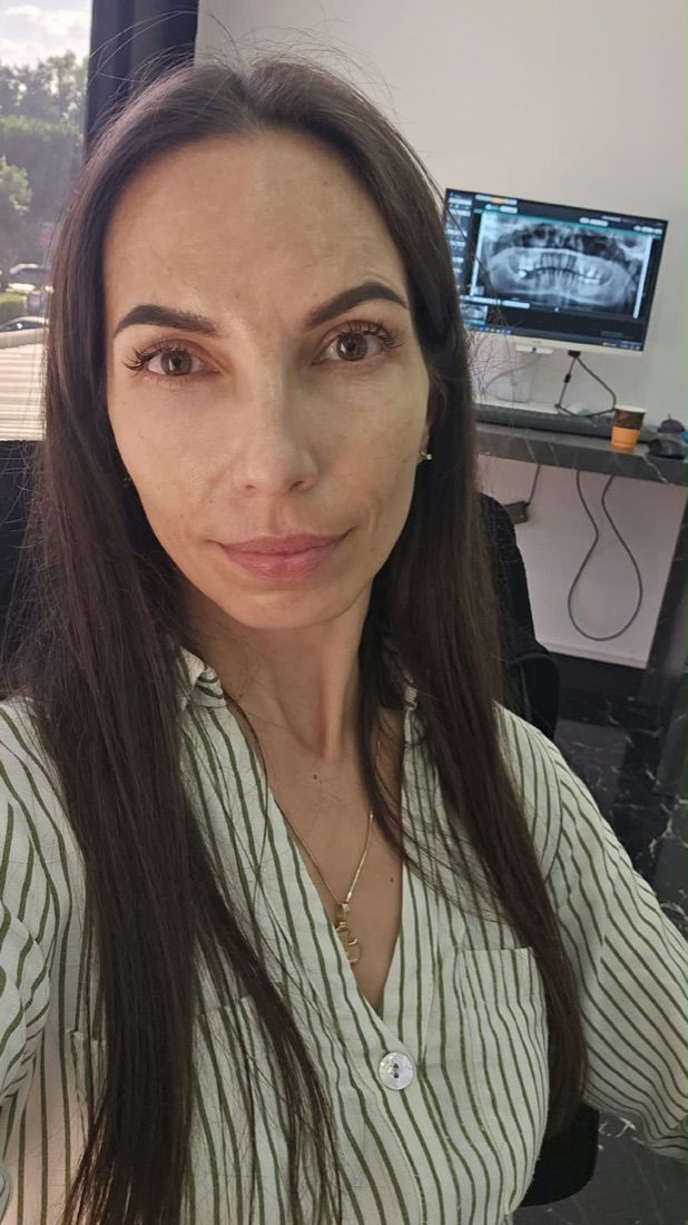 Renata w gabinecie, w tle monitor ze zdjęciem panoramicznym zębów